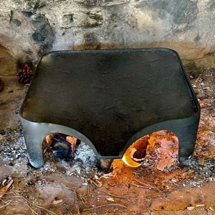 Plancha avec pied sur braises