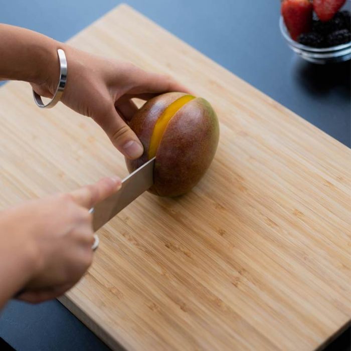 Découpe mangue sur planche à découper en bambou